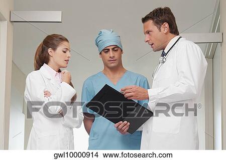 Three doctors discussing in a hospital View Large Photo Image Picture - Three doctors discussing in a hospital. Fotosearch