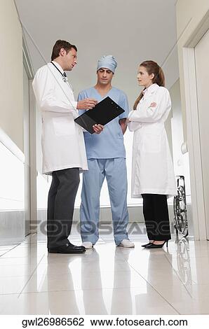 Three doctors discussing in a hospital View Large Photo Image Stock Image - Three doctors discussing in a hospital. Fotosearch