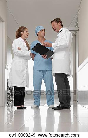 Three doctors discussing in a hospital View Large Photo Image Stock Photo - Three doctors discussing in a hospital. Fotosearch