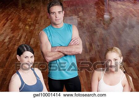 Picture - Three people smiling in a gym. Fotosearch