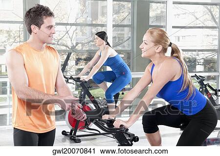 Three people working out in a gym View Large Photo Image Stock Image - Three people working out in a gym. Fotosearch