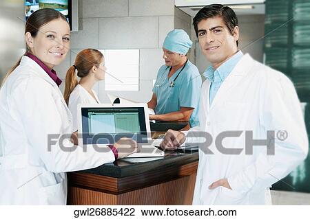 Two doctors discussing a medical report on a laptop View Large Photo Image Stock Image - Two doctors discussing a medical report on a laptop. Fotosearch