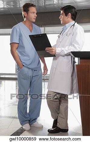 Two doctors discussing a medical report View Large Photo Image Stock Photo - Two doctors discussing a medical report. Fotosearch
