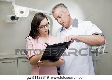 Two doctors discussing a report View Large Photo Image Stock Photo - Two doctors discussing a report. Fotosearch