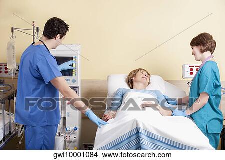 Picture - Two doctors examining a patient. Fotosearch