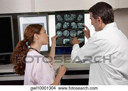 Two doctors examining MRI report View Large Photo Image Picture - Two doctors examining MRI report. Fotosearch