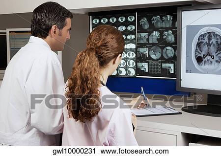 Stock Image - Two doctors examining MRI report. Fotosearch