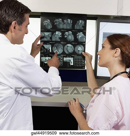 Stock Photo - Two doctors examining MRI report. Fotosearch