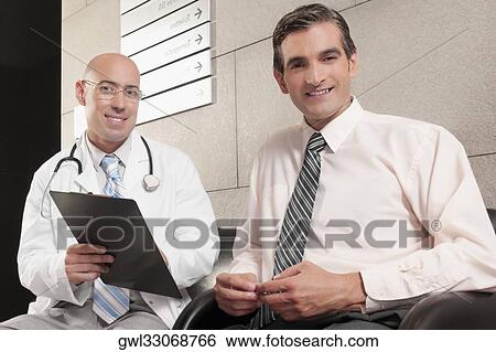 Two doctors smiling with a medical report View Large Photo Image Stock Photograph - Two doctors smiling with a medical report. Fotosearch