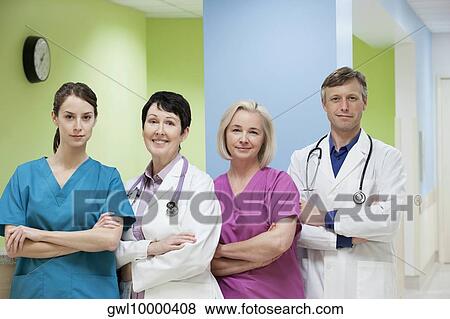 Stock Photo - Two doctors standing with two nurses and smiling. Fotosearch
