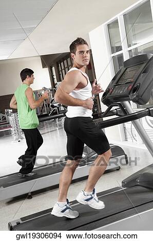 Two men running on treadmills View Large Photo Image Picture - Two men running on treadmills. Fotosearch