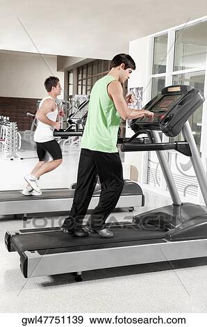 Two men running on treadmills View Large Photo Image Stock Photo - Two men running on treadmills. Fotosearch