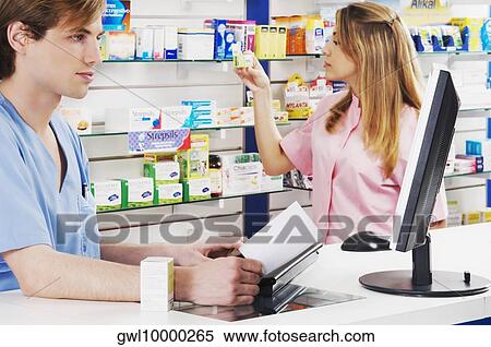 Two pharmacists in a pharmacy View Large Photo Image Stock Photography - Two pharmacists in a pharmacy. Fotosearch