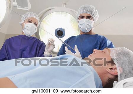 Two surgeons operating a patient in an operating room View Large Photo Image Stock Photo - Two surgeons operating a patient in an operating room. Fotosearch
