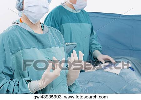 Two surgeons performing a surgery in an operating room View Large Photo Image Stock Image - Two surgeons performing a surgery in an operating room. Fotosearch