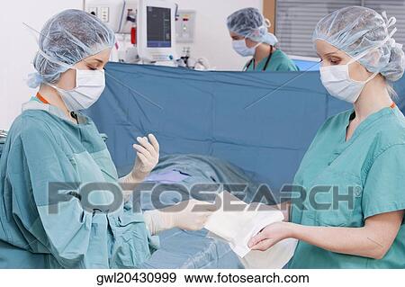 Stock Photo - Two surgeons performing a surgery in an operating room. Fotosearch