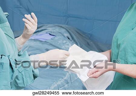 Two surgeons performing a surgery in an operating room View Large Photo Image Stock Photography - Two surgeons performing a surgery in an operating room. Fotosearch