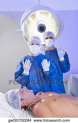 Two surgeons with a patient in an operating room View Large Photo Image Picture - Two surgeons with a patient in an operating room. Fotosearch