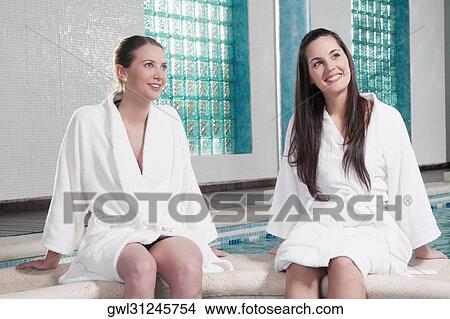 Two women sitting at the poolside View Large Photo Image Picture - Two women sitting at the poolside. Fotosearch