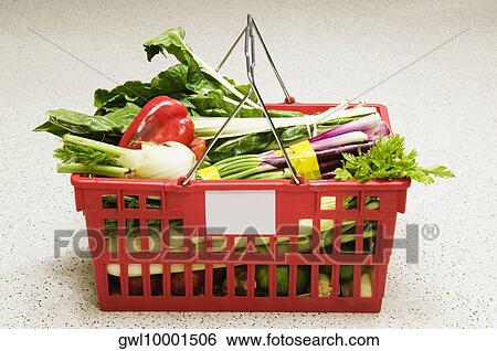 Stock Photograph - Vegetables in a shopping basket in a supermarket. Fotosearch