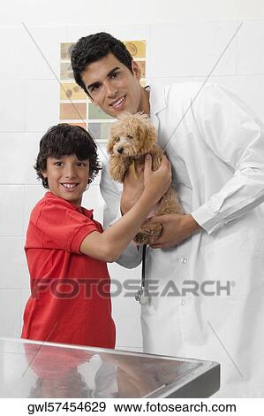Vet and a boy carrying a dog View Large Photo Image Stock Photo - Vet and a boy carrying a dog. Fotosearch