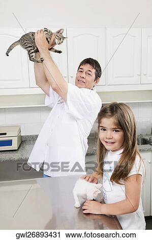Vet and a girl playing with cats View Large Photo Image Stock Image - Vet and a girl playing with cats. Fotosearch