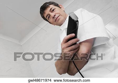 Vet holding an electric razor View Large Photo Image Picture - Vet holding an electric razor. Fotosearch