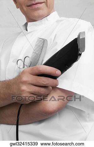 Vet holding an electric razor View Large Photo Image Stock Photo - Vet holding an electric razor. Fotosearch