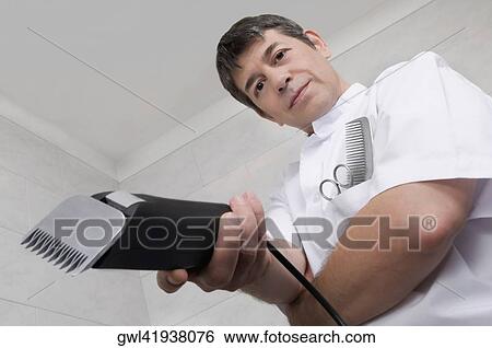 Vet holding an electric razor View Large Photo Image Stock Photograph - Vet holding an electric razor. Fotosearch