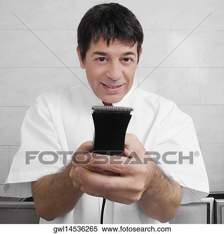 Vet holding an electric razor View Large Photo Image Stock Photography - Vet holding an electric razor. Fotosearch
