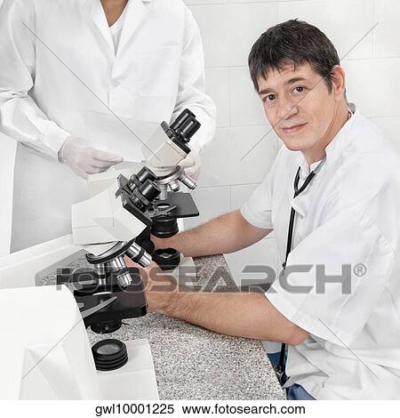 Vet looking into a microscope View Large Photo Image Stock Photography - Vet looking into a microscope. Fotosearch