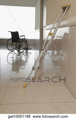 Wheelchair with a crutch in the corridor of a hospital View Large Photo Image Stock Photograph - Wheelchair with a crutch in the corridor of a hospital. Fotosearch