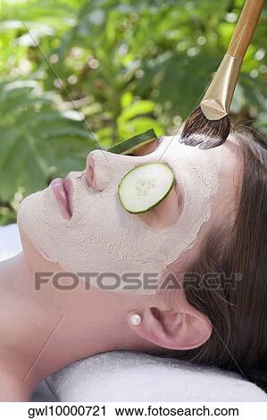 Stock Image - Woman applying a facial mask. Fotosearch