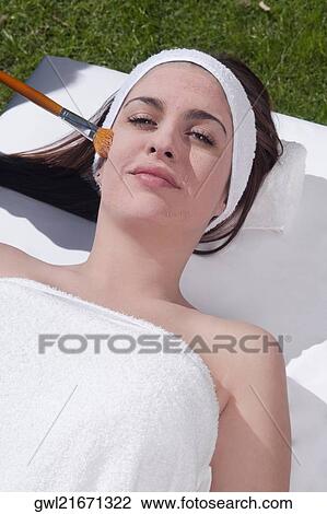 Stock Image - Woman applying a facial mask. Fotosearch