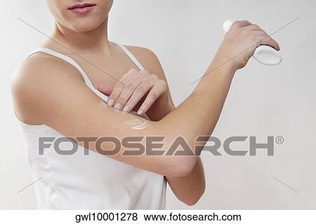 Woman applying moisturizer cream on her arm View Large Photo Image Stock Photo - Woman applying moisturizer cream on her arm. Fotosearch