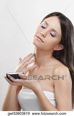 Stock Photo - Woman applying moisturizer cream on her neck. Fotosearch