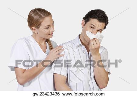 Stock Photograph - Woman beside a man suffering from cold. Fotosearch