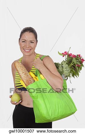 Woman carrying a bag of groceries View Large Photo Image Stock Photo - Woman carrying a bag of groceries. Fotosearch