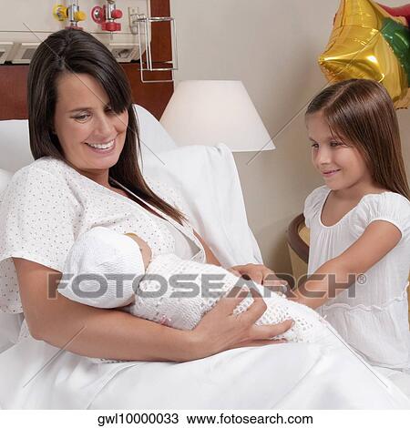 Woman carrying her newborn baby with her daughter in a hospital View Large Photo Image Stock Image - Woman carrying her newborn baby with her daughter in a hospital. Fotosearch