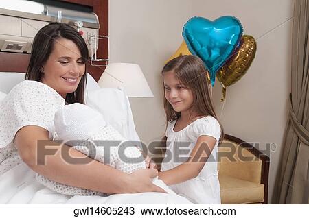 Woman carrying her newborn baby with her daughter in a hospital View Large Photo Image Stock Image - Woman carrying her newborn baby with her daughter in a hospital. Fotosearch