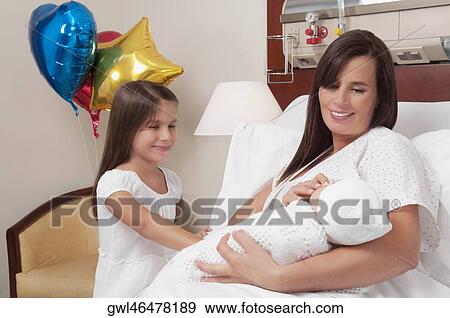 Woman carrying her newborn baby with her daughter in a hospital View Large Photo Image Stock Photo - Woman carrying her newborn baby with her daughter in a hospital. Fotosearch