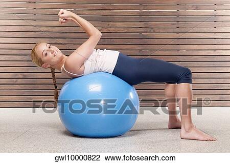 Stock Image - Woman doing sit-ups on a fitness ball. Fotosearch