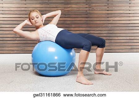 Woman doing sit-ups on a fitness ball View Large Photo Image Stock Photograph - Woman doing sit-ups on a fitness ball. Fotosearch
