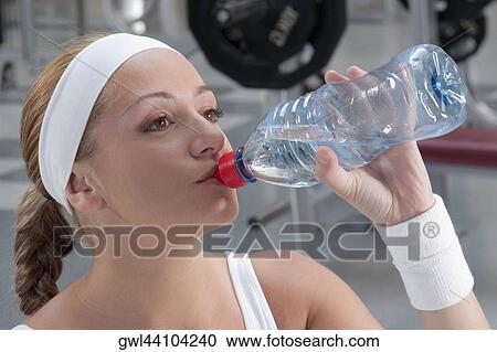 Woman drinking water from a water bottle View Large Photo Image Stock Image - Woman drinking water from a water bottle. Fotosearch