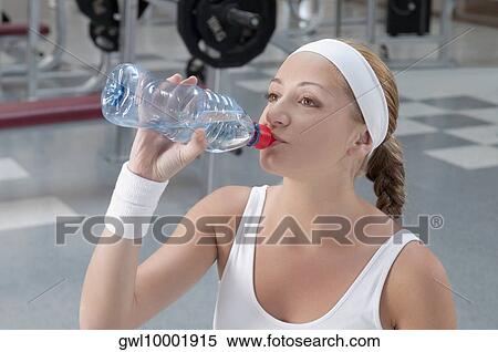 Woman drinking water from a water bottle View Large Photo Image Stock Photography - Woman drinking water from a water bottle. Fotosearch