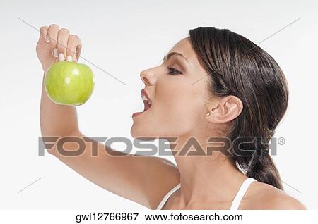 Woman eating a green apple View Large Photo Image Stock Photo - Woman eating a green apple. Fotosearch