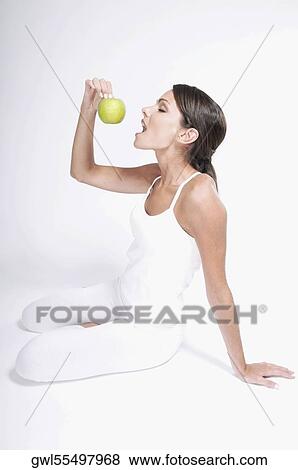 Woman eating a green apple View Large Photo Image Stock Photo - Woman eating a green apple. Fotosearch