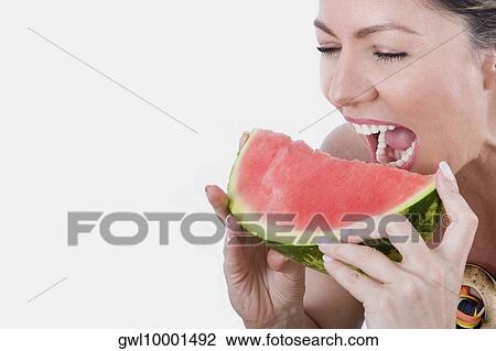 Stock Image - Woman eating watermelon. Fotosearch