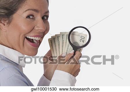 Woman examining currency notes with a magnifying glass View Large Photo Image Stock Image - Woman examining currency notes with a magnifying glass. Fotosearch