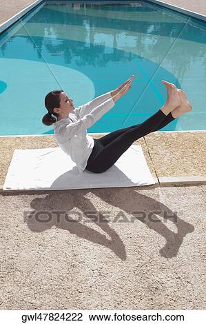 Woman exercising at the poolside View Large Photo Image Stock Image - Woman exercising at the poolside. Fotosearch